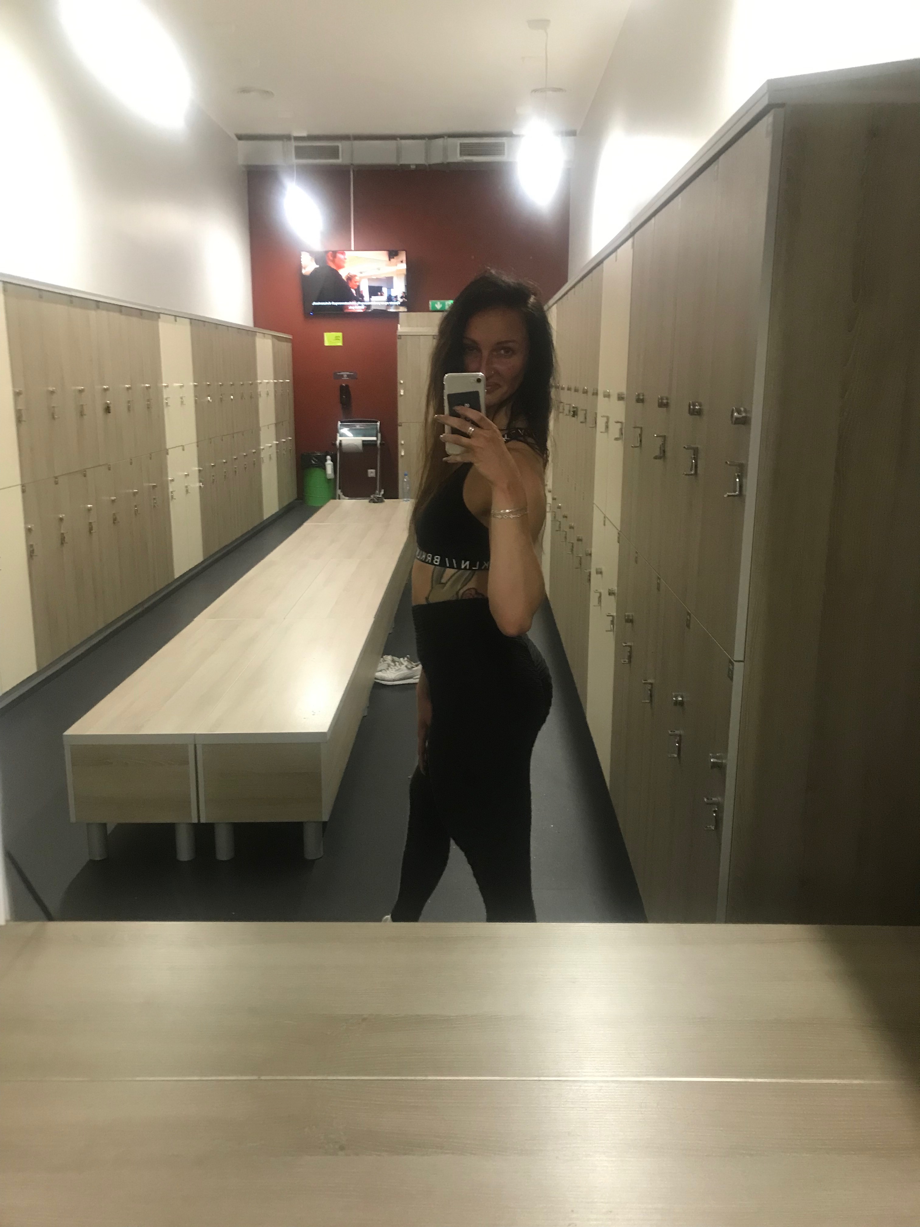 Kobieta w czarnej stylizacji w lustrze szatni, pionowy kadr, wnętrze | Женщина в черном образе в зеркале раздевалки, вертикальный кадр, интерьер